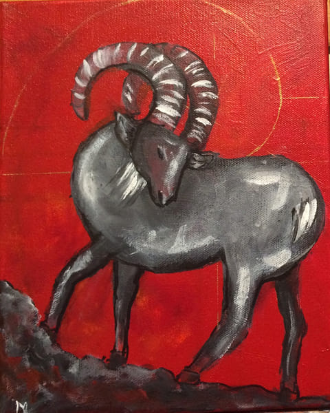 Painted gray ram with large curved striped horns standing on dark rocks against a bright red background